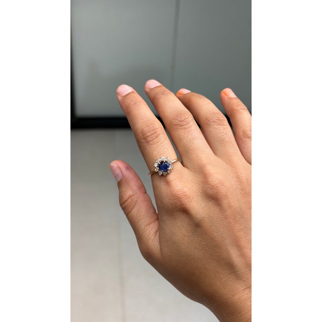 This Victorian-inspired floral halo ring features a 1.22-carat natural blue sapphire, set in 14K yellow gold. The center...