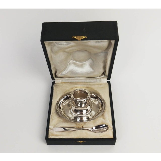 Art Deco style silver-plated egg cup and spoon. The egg cup's base forms a plate, and the removable cylindrical part fits...