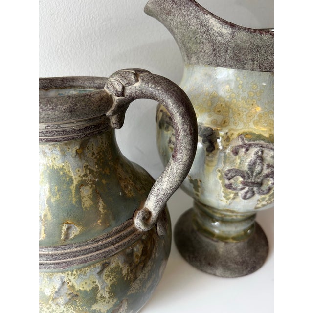 Vintage, stoneware, matching sister pitchers or vases. Both with a gloss base of antiqued or distressed sage, verdigris...