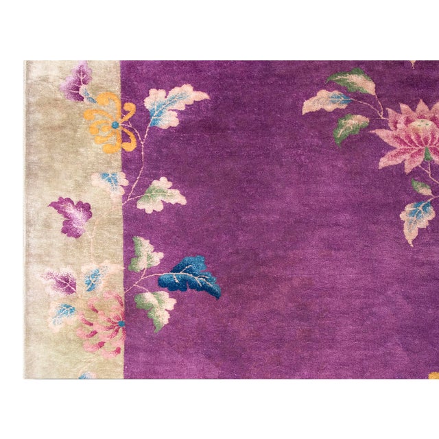 This exquisite 1930s Chinese Art Deco rug features a vibrant purple field adorned with an elegant natural design of...