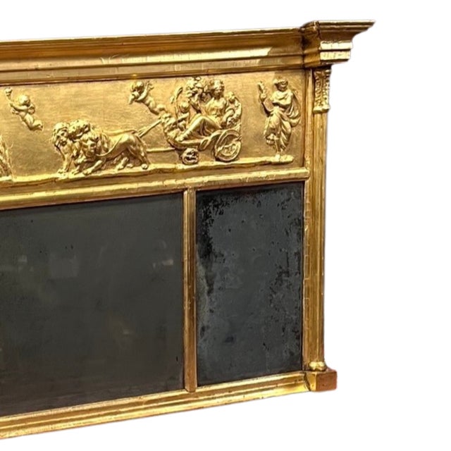An early 19th century classical style overmantel mirror, circa 1830. The mirror is an elongated rectangle with a frieze...