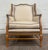 This is a vintage Country French wingback chair possibly attributed to Baker Furniture, featuring a warm fruitwood frame,...