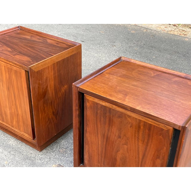 Pair of walnut nightstands by Merton Gershun for Dillingham, c.1960s, USA. The nightstands each feature a single door...