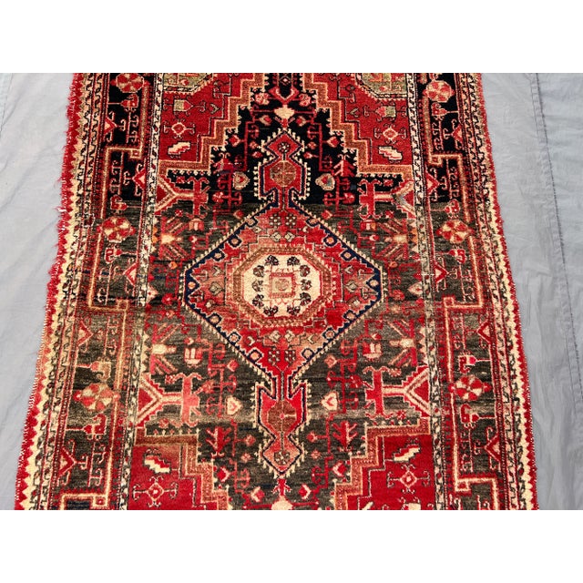 This antique Caucasian medallion rug is a remarkable example of regional artistry, featuring a bold red and charcoal color...