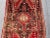 This antique Caucasian medallion rug is a remarkable example of regional artistry, featuring a bold red and charcoal color...