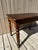 Charming antique bistro table in solid walnut, showcasing a beautiful dark brown patina acquired over time. It rests on...