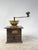 Charming coffee grinder with a solid wood body and brass top hopper. Perfect for display or as a collector's item.