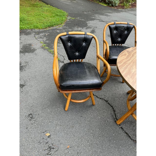 Gorgeous 1960s-1970s vintage rattan dining set with black vinyl cushioned seats Table is 42” in diameter 27“ high chairs...