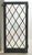 Tudor style casement stained glass window with a leaded diamond pattern in a pastel color scheme. The frame is made of...