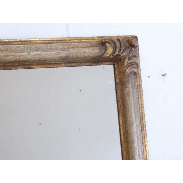 This mirror with carved gilded corners, has an overall ivory tone with a gilded edge. It measures 50.5"H x 25.5"W.