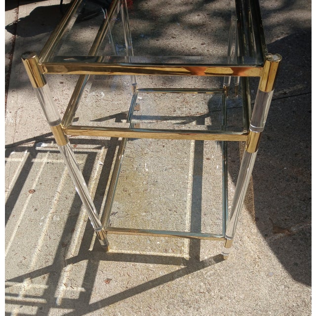 Vintage 1980s brass shelve table, with lucite acrylic legs. 3 Tempered beveled glass inserts. A mid-century gem attributed...