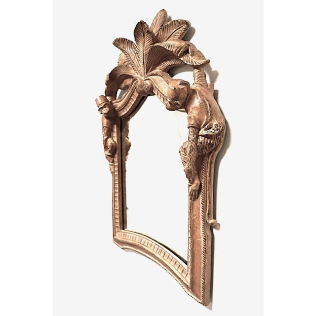 1980s carved wood monkey and palm frond wall mirror in the Hollywood Regency, Palm Beach, and Chinoiserie style, featuring...