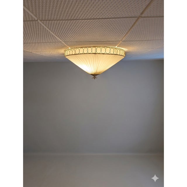 The ceiling lamp was probably designed by Paavo Tynell and manufactured by Idman in Finland in the 1950s. This lamp is...