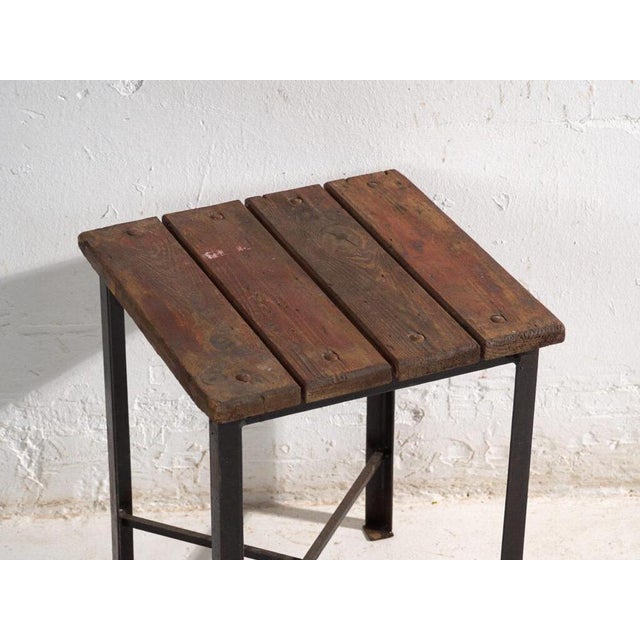 This antique industrial stool in pine wood and iron is an industrial seat with a tubular iron frame and a pine slatted...