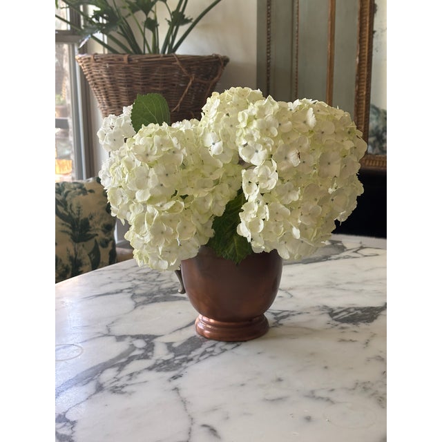 A beautifully patinated vintage copper pitcher featuring a classic rounded form, flared pouring lip and contrasting brass...