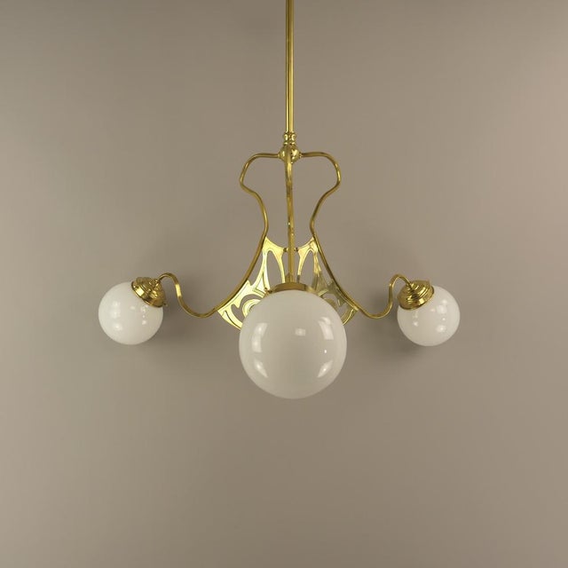 Dreiarmige Art Deco Kronleuchter mit opalem Kugelschirm Three-arm Art Deco chandelier Vienna with opal ball shade The lamp...