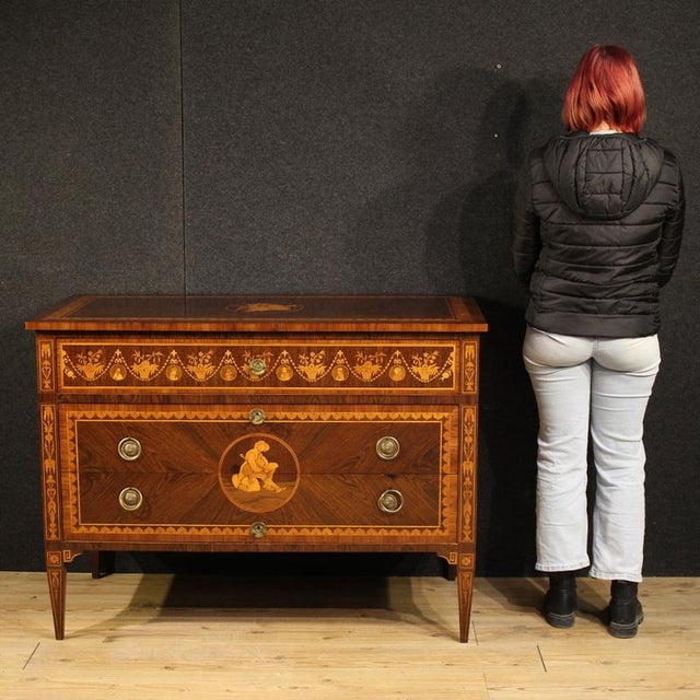 An elegant mid-20th-century Italian dresser. This Louis XVI-style furniture is richly inlaid with walnut, rosewood, maple,...