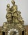 An elegant Vintage brass clock featuring an ornate figural design with a beautifully detailed romantic scene above the...
