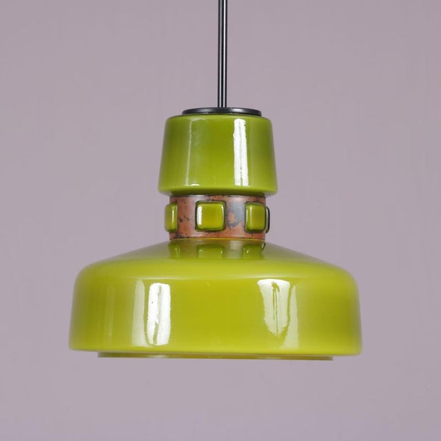 1970s hanging lamp in green glass with copper details, designed by victor berndt for flygsfors, sweden. A distinctive...