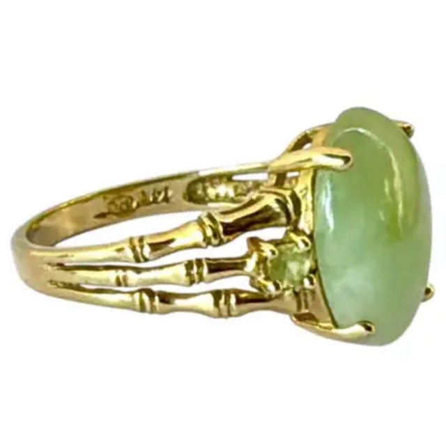 Vintage Chinese 14K Yellow Gold Jade Cocktail Ring. Center oval jade stone is flanked by two small round pale-green...