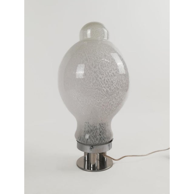 A Splendid giant Italian table lamp made in Murano blown glass and chromed metal. Datable to around the 1970s, the lamp...