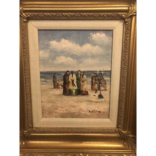 This is an oil on canvas painting depicting a group of people, seaside. The gilt frame is finely hand carved. The piece is...