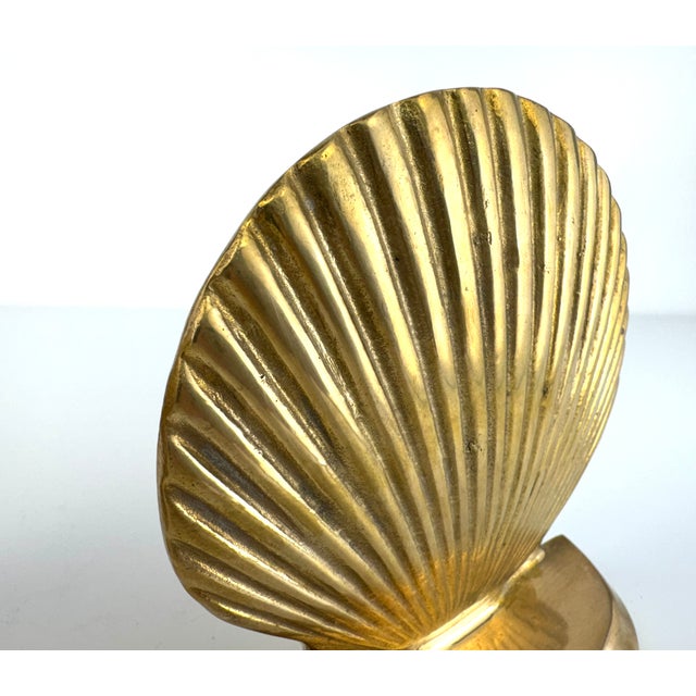 A stunning pair of mid-century solid brass bookends cast in the form of scallop seashells—an iconic coastal motif popular...
