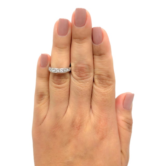 Tiffany & Co. wedding band ring from the "Tiffany setting" collection finely crafted in platinum featuring 9 round...