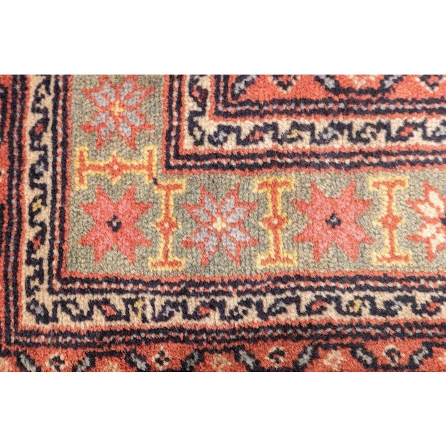 The straw-sand field displays 16 full, and two half offset rows of geometric floral elements based uniformly on charcoal...