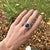A tanzanite takes centre stage in a deep violet-blue at the centre of this solid 14K white gold ring, accented with earth-...