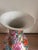 A striking vintage Chinese porcelain vase in the Famille Rose style, richly decorated with an exuberant allover botanical...