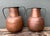 This striking pair of vintage Moroccan water jugs is a masterclass in traditional North African metalwork and rustic...