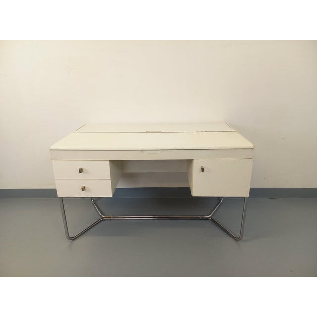 Vintage 1970s desk, Bauhaus or Space Age style, with a cream-white melamine top and storage compartments, and a tubular...