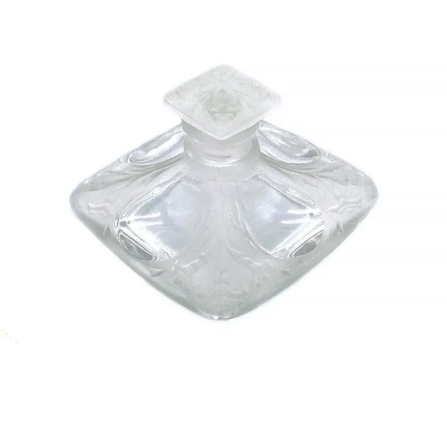 This is a molded glass perfume bottle with stopper. It has a short square shaped body and stopper bottle with clear and...