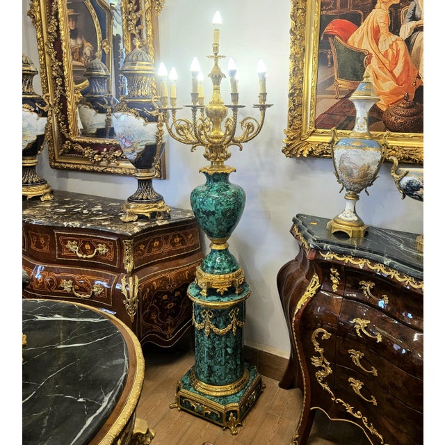 An impressive piece of Louis XVI-style candelabra with shaped porcelain bases, each hand-painted with finely detailed...