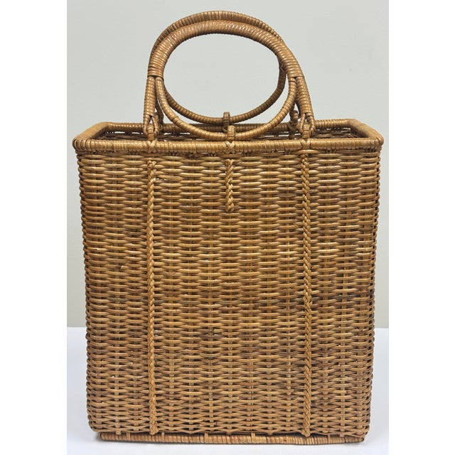 Vintage woven wicker basket featuring tall slim form and round handles to either side. Unique shape for that space that...