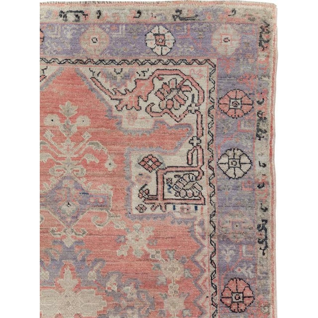 This mid-20th-century Turkish Anatolian accent rug presents a richly layered medallion composition across a muted coral...