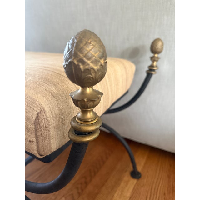Stunning condition iron curule bench. Beautiful brass finials. Bench pops out for easy reupholstering. 17” wide 22.5” deep...