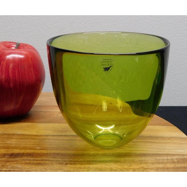 2pc Art Glass Collection: Signed Orrefors Green Bowl & Cobalt Blue Hurricane Elevate your home décor with this curated...