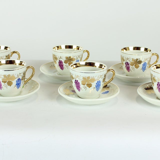 An elegant and highly decorative set of six porcelain tea or coffee cups with matching saucers, produced by the renowned...