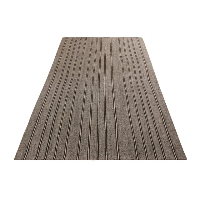 A vintage 5x7 Kilim rug in handwoven wool, originating from Turkey circa 1950-1960. Enjoying a forgiving, versatile gray...