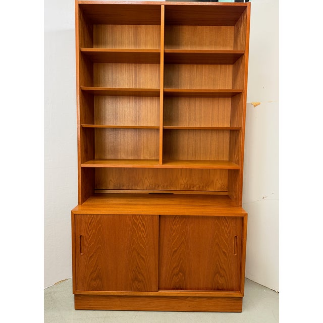 Sculptural Danish teak wall unit by Hundevad & Co., Denmark, dating to the 1990s, combining open bookshelf storage, a...
