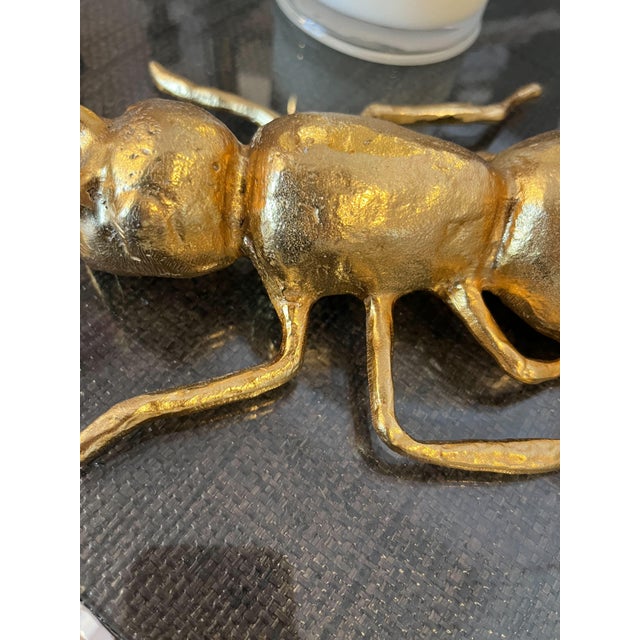 Add a touch of whimsical charm to any vignette with a Wisteria insect in shiny gold finish.