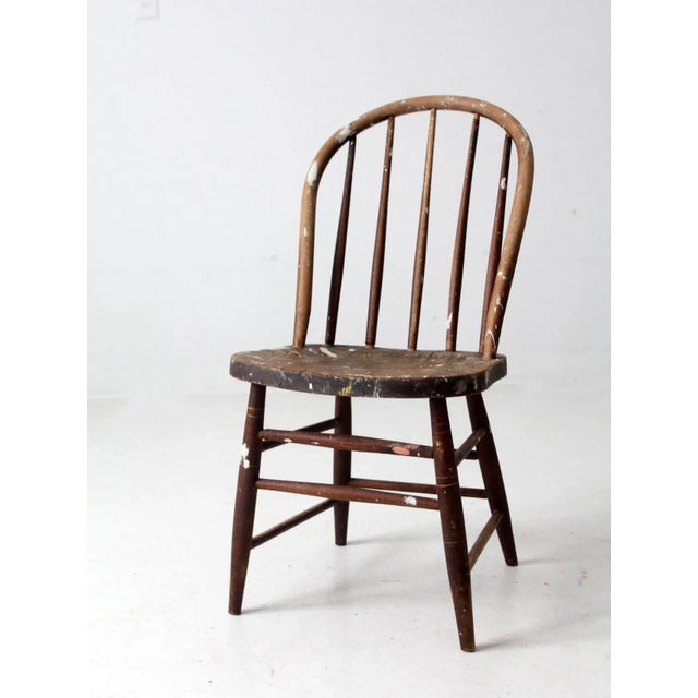 This classic Windsor chair features a bowed spindle back and a charming splattering of white paint. A perfect addition to...