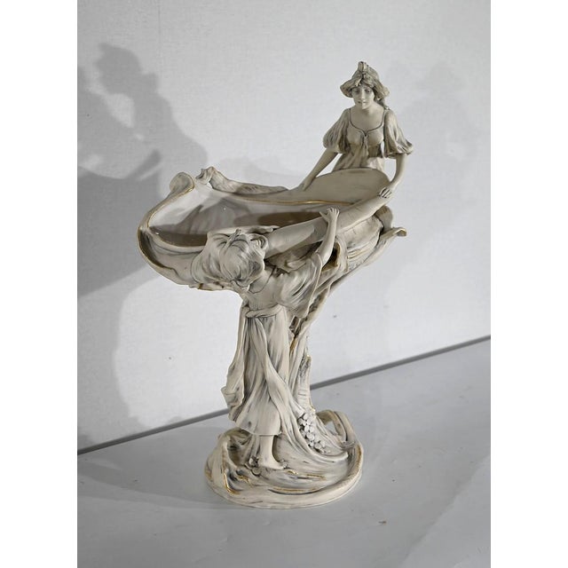 This important broken white porcelain cut, enhanced with gold border, is signed by the famous Royal Dux Manufacture. The...