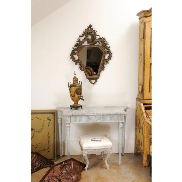 An Italian Rococo style carved mirror from the 19th century, with traces of gilt. Created in Italy during the 19th...