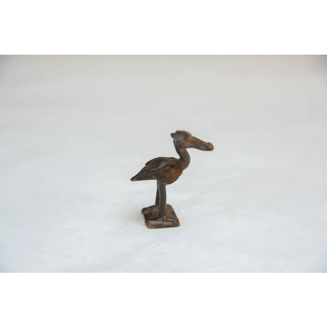 Vintage handmade African curious crowned bird with nut. Circa mid 20th century and possibly older, this piece has such...