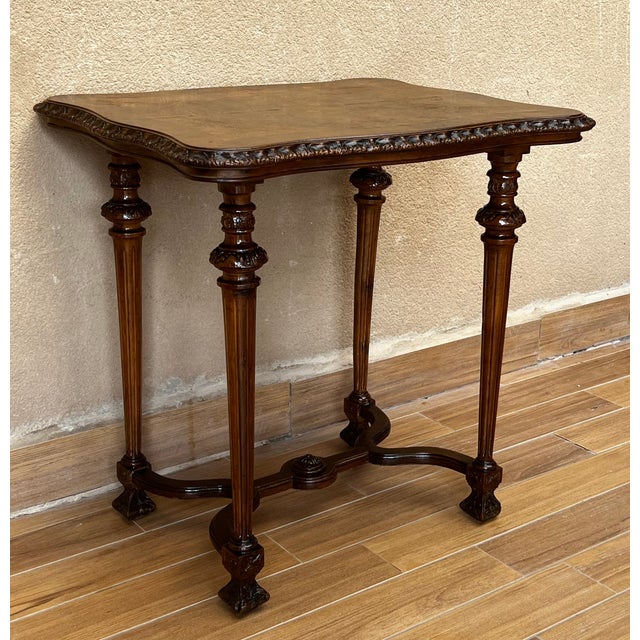 About An Italian walnut side table from the 19th century, with carved apron and fluted legs. Created in Spain during the...