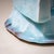 The vase is covered in a pale blue, translucent Seihakuji glaze. The irregular base transitions into quasi-geometric,...