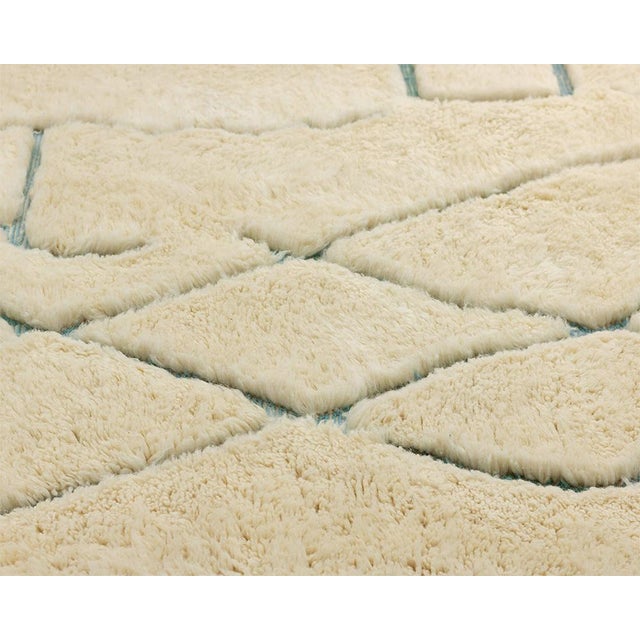 Whimsical aqua blue lines wander freely across a warm cream field, crossing and curving like a hand-sketched doodle...